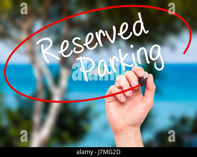 Man Hand writing Reserved Parking with black marker on visual screen. Isolated on nature. Business, technology, internet concept. Stock Photo Stock Photo