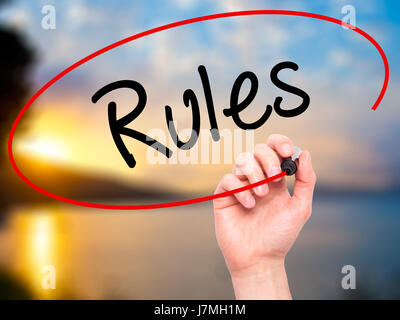 Man Hand writing Rules with black marker on visual screen. Isolated on background. Business, technology, internet concept. Stock Photo Stock Photo