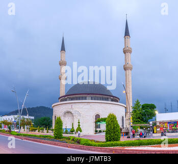 KEMER, TURKEY - MAY 5, 2017: The New Merkez Mosque with two tall minarets surrounded by perfectly trimmed trees and tourist stalls, on May 5 in Kemer. Stock Photo