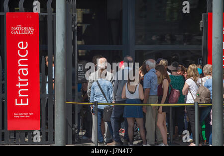 London, UK. 25th May 2017. Commuters and tourists enjoy hot sunshine and high temperatures this morning. Long visitor queues in the sun at the Nationa Gallery for security bag searches. Credit: Malcolm Park editorial/Alamy Live News. Stock Photo