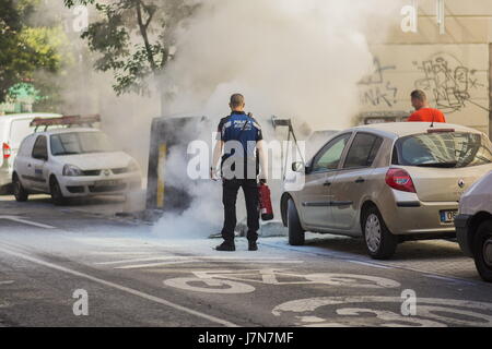 Madrid, Spain. 25th May, 2017. The police extinguish the fire of a garbage container Credit: F. J. Carneros/Alamy Live News Stock Photo