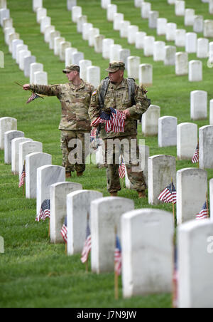 Arlington, USA. 25th May, 2017. Soldiers from the 3rd U.S. Infantry Regiment place flags at grave sites during the 'Flags-In' ceremony at the Arlington National Cemetery in Arlington, Virginia, the United States, on May 25, 2017. More than 1,000 soldiers placed flags for over 284,000 graves in the cemetery ahead of Memorial Day, the last Monday of May. Credit: Yin Bogu/Xinhua/Alamy Live News Stock Photo