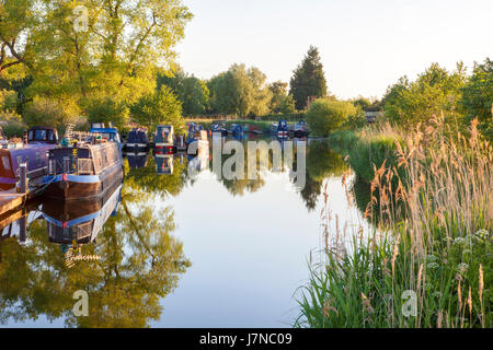 Canal boat reflections in Rufford, Lancashire, May 2017. UK Weather.  A beautiful sunrise lights up the canal boats moored on Rufford Marina in Lancashire.  This local beauty spot is located just off the Leeds/Liverpool canal.  With it's stunning viewpoints and on site cafe's, it is a very popular resting place for those travelling this famous East to West route.  Credit: Cernan Elias/Alamy Live News Stock Photo