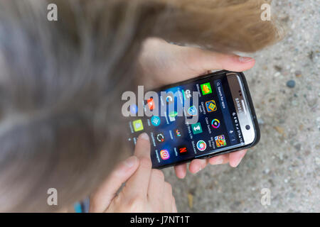 A girl using touchscreen mobile phone / smartphone apps Stock Photo