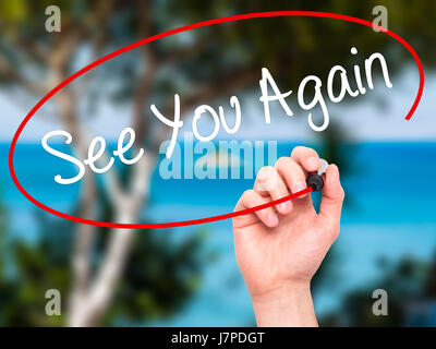 Man Hand writing See You Again with black marker on visual screen. Isolated on nature. Business, technology, internet concept. Stock Photo Stock Photo