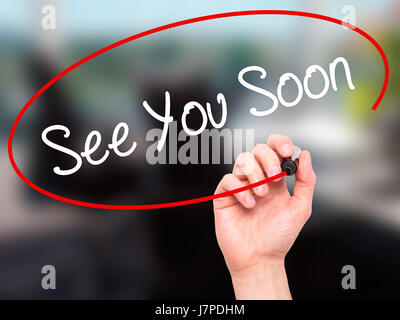 Man Hand writing See You Soon with black marker on visual screen. Isolated on background. Business, technology, internet concept. Stock Photo Stock Photo