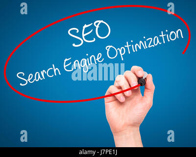 Man Hand writing SEO Search Engine Optimization with black marker on visual screen. Isolated on blue. Business, technology, internet concept. Stock Ph Stock Photo