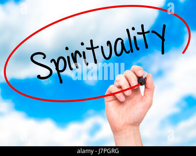 Man Hand writing Spirituality with black marker on visual screen. Isolated on sky. Business, technology, internet concept. Stock Photo Stock Photo