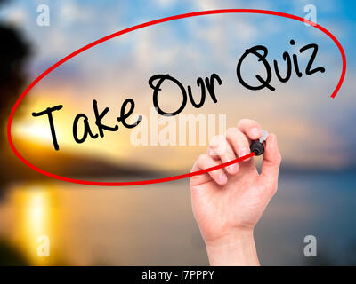 Man Hand writing Take Our Quiz with black marker on visual screen. Isolated on nature. Business, technology, internet concept. Stock Photo Stock Photo