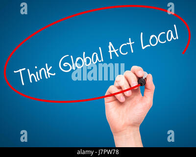 Man Hand writing Think Global Act Local with black marker on visual screen. Isolated on blue. Business, technology, internet concept. Stock Photo Stock Photo