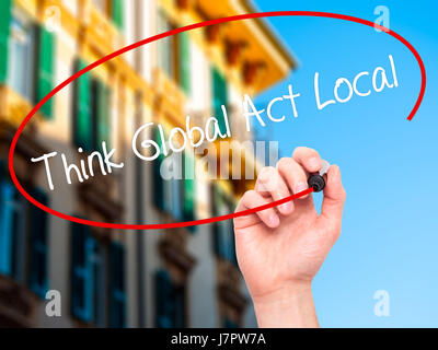 Man Hand writing Think Global Act Local with black marker on visual screen. Isolated on city. Business, technology, internet concept. Stock Photo Stock Photo