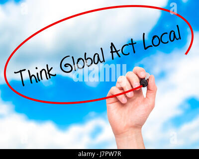 Man Hand writing Think Global Act Local with black marker on visual screen. Isolated on sky. Business, technology, internet concept. Stock Photo Stock Photo