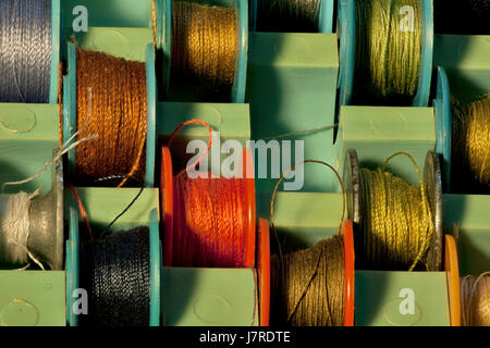 thread on tailor bobbins for sewing machine in box close to Stock Photo