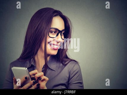 Beautiful woman using smart phone looking away laughing Stock Photo
