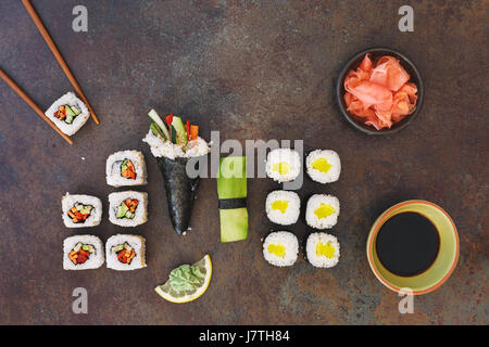 Vegetarian sushi with soy sauce,wasabi  and pickled ginger, served on stone background. Top view, blank space Stock Photo
