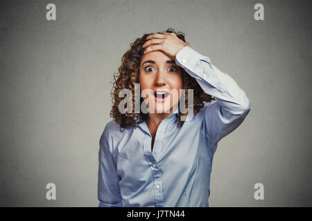 Surprise astonished woman. Closeup portrait woman looking surprised in full disbelief wide open mouth isolated gray wall background. Positive human em Stock Photo