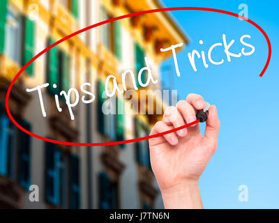 Man Hand writing Tips and Tricks with black marker on visual screen ...