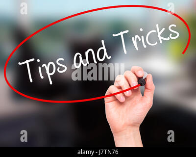 Man Hand writing Tips and Tricks with black marker on visual screen ...