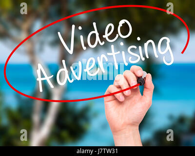 Man Hand writing Video Advertising with black marker on visual screen. Isolated on nature. Business, technology, internet concept. Stock Photo Stock Photo