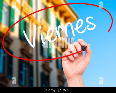 Man Hand writing Viernes (Friday in Spanish) with black marker on visual screen. Isolated on city. Business, technology, internet concept. Stock Photo Stock Photo