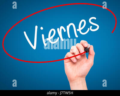 Man Hand writing Viernes (Friday in Spanish) with black marker on visual screen. Isolated on blue. Business, technology, internet concept. Stock Photo Stock Photo