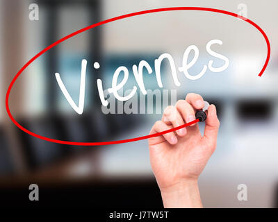 Man Hand writing Viernes (Friday in Spanish) with black marker on visual screen. Isolated on office. Business, technology, internet concept. Stock Pho Stock Photo