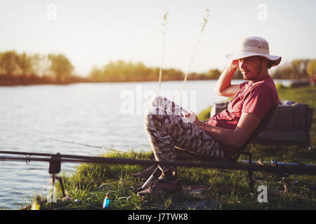 Men fishing in sunset and relaxing while enjoying hobby Stock Photo