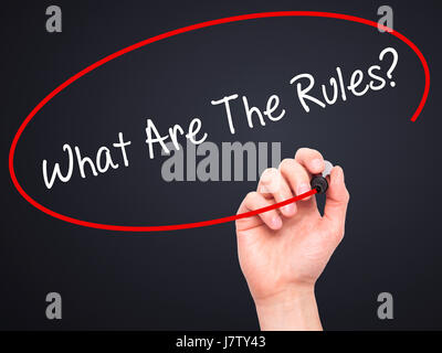 Man Hand writing What Are The Rules?  with black marker on visual screen. Isolated on black. Business, technology, internet concept. Stock Photo Stock Photo