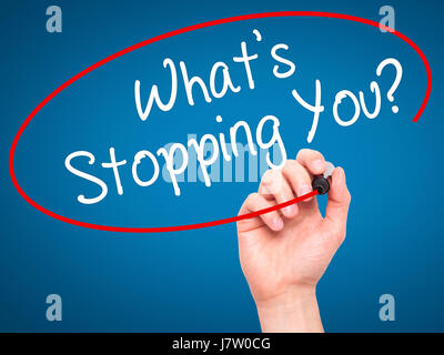 Man Hand writing What's Stopping You?  with black marker on visual screen. Isolated on blue. Business, technology, internet concept. Stock Photo Stock Photo