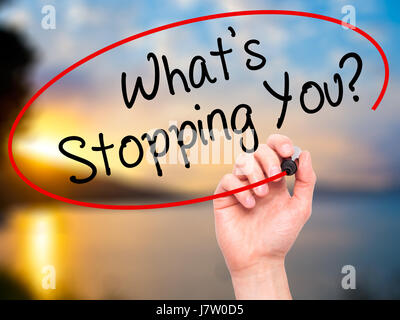 Man Hand writing What's Stopping You?  with black marker on visual screen. Isolated on nature. Business, technology, internet concept. Stock Photo Stock Photo