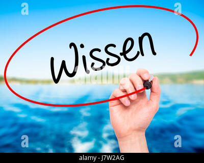 Man Hand writing Wissen (Know in German)  with black marker on visual screen. Isolated on background. Business, technology, internet concept. Stock Ph Stock Photo