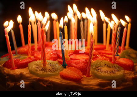 Birthday cake with burning candles on a dark background Stock Photo