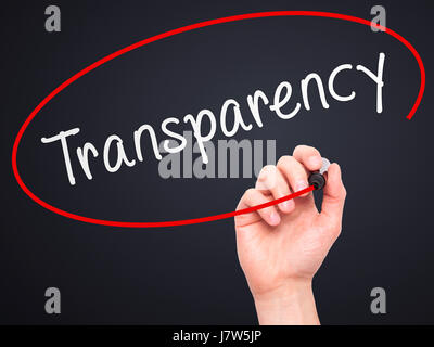 Man Hand writing Transparency with marker on transparent wipe board. Isolated on black. Business, internet, technology concept.  Stock Photo Stock Photo