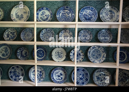 A collection of blue and white ceramic plates from China, Japan, and the Netherlands, displayed at Kelmscott Manor in Oxfordshire, England. These plates represent the distinct ceramic traditions and artistry of their respective cultures. Stock Photo