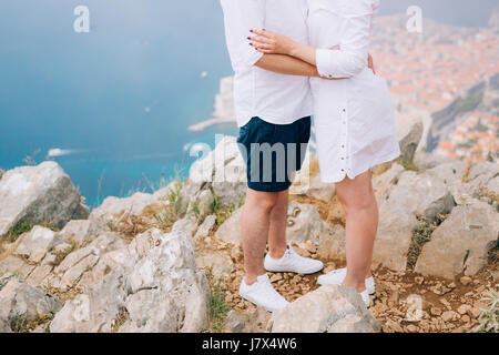 The newlyweds hold hands on a viewing platform over Dubrovnik. Couple holding hands. Wedding in Croatia. Stock Photo