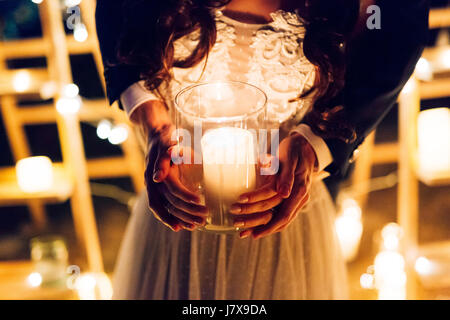 A candle in the hands of a newlywed couple. Wedding in Montenegr Stock Photo