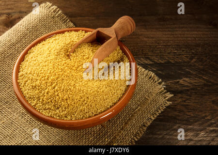 Bowl of couscous on rustic textures with copyspace Stock Photo