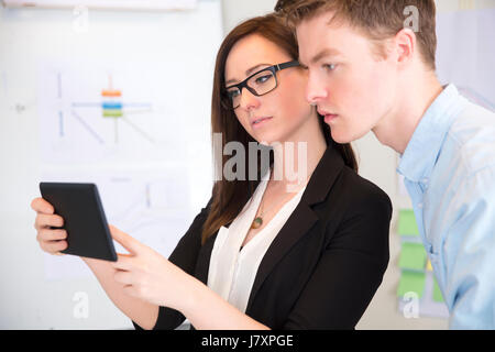 Businesswoman Using Tablet Computer With Male Colleague Stock Photo