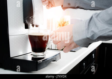 Man making black coffee in glass with coffee machine. coffee machine lungo kitchen glass hot italian concept Stock Photo