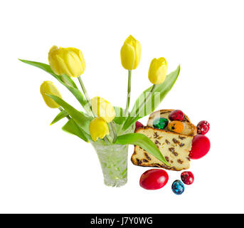 Yellow tulips with cake called Pasca made with cheese and raisins, traditional colored easter eggs Stock Photo