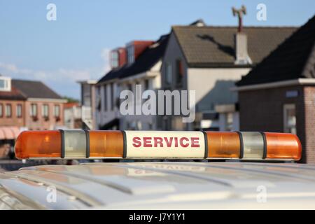 service vehicle with yellow beacon lights in urban area Stock Photo