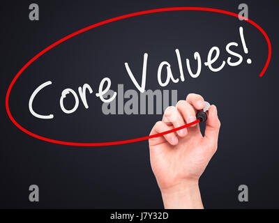 Man Hand writing Core Values with marker on transparent wipe board. Isolated on black. Business, internet, technology concept. Stock Photo Stock Photo