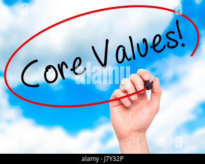 Man Hand writing Core Values with marker on transparent wipe board. Isolated on sky. Business, internet, technology concept. Stock Photo Stock Photo
