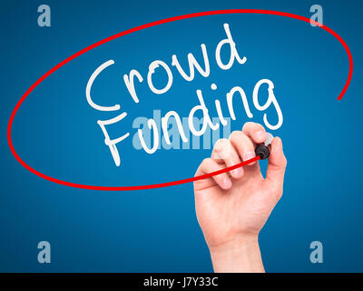 Man Hand writing Crowd Funding with marker on transparent wipe board. Isolated on blue. Business, internet, technology concept. Stock Photo Stock Photo