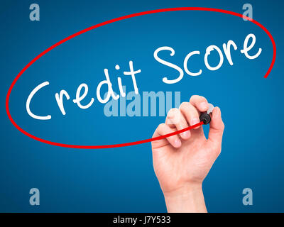 Man Hand writing Credit Score black marker on visual screen. Isolated on blue. Business, technology, internet concept. Stock Image Stock Photo
