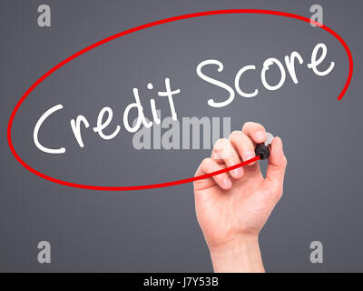 Man Hand writing Credit Score black marker on visual screen. Isolated on grey. Business, technology, internet concept. Stock Image Stock Photo