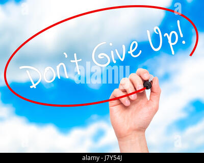 Man Hand writing Don't Give Up with black marker on visual screen. Isolated on sky. Business, technology, internet concept. Stock Image Stock Photo