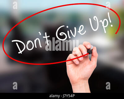 Man Hand writing Don't Give Up with black marker on visual screen. Isolated on office. Business, technology, internet concept. Stock Image Stock Photo