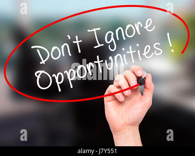 Man Hand writing Don't Ignore Opportunities black marker on visual screen. Isolated on office. Business, technology, internet concept. Stock Image Stock Photo