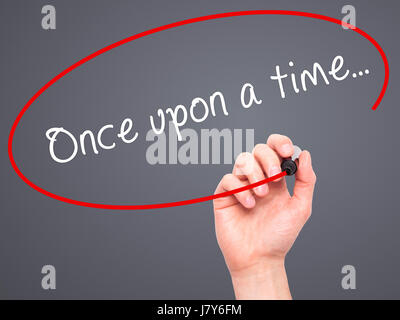 Man Hand writing Once upon a time... with black marker on visual screen. Isolated on grey. Business, technology, internet concept. Stock Image Stock Photo